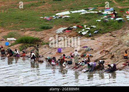 Women are seen washing their clothes in Lilongwe river as the children play. Malingunde, Malawi. Stock Photo