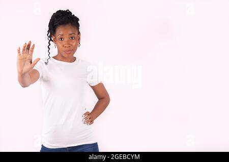 Afro american woman with a stern face holding her hand at the camera Stock Photo