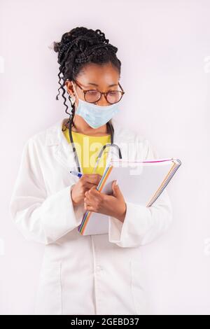 Afro american female doctor with a mask taking notes Stock Photo