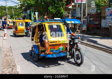 BORACAY, PHILIPPINES - MARCH 04, 2013: Tricycle at the main street in Boracay island. Tricycle is a very popular public taxi transport in Philippines. Stock Photo