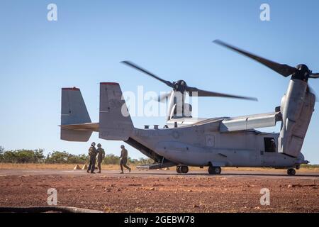 Australian Army Maj. Gen. Matt Pearse, center, commander of Forces Command, is greeted by a U.S. Marine Corps crew chief after exiting an MV-22B Osprey with Marine Medium Tiltrotor Squadron 363 (Reinforced), Marine Rotational Force – Darwin, at Bradshaw Field Training Area, NT, Australia, Aug. 16, 2021. U.S. Marines and Australian Army forces hosted leaders from Forces Command to observe units training within Exercise Koolendong to show interoperability between the Australian Defence Force and the Marine Corps. Exercise Koolendong validates MRF-D’s and the ADF’s ability to conduct expeditionar Stock Photo