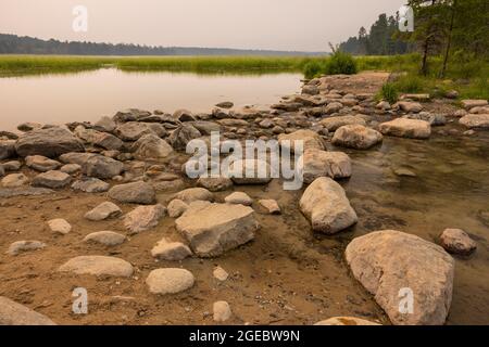 The headwaters of the Mississippi River at Lake Itasca. There's a smokey haze from wildfires. Stock Photo