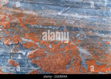 Orange rust coating on gray surface of stone. Background, texture. Stock Photo