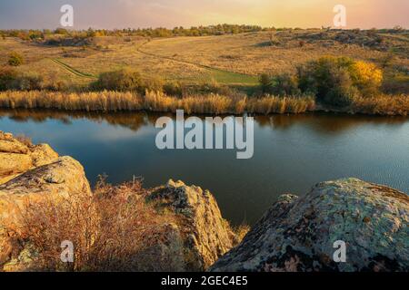 A small pile of stones in a green-yellow field against the background of sky in beautiful Ukraine Stock Photo