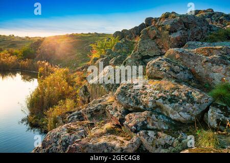 A small pile of stones in a green-yellow field against the background of sky in beautiful Ukraine Stock Photo