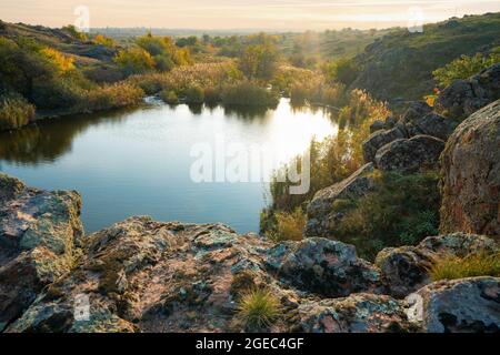 A small pile of stones in a green-yellow field against the background of sky in beautiful Ukraine Stock Photo