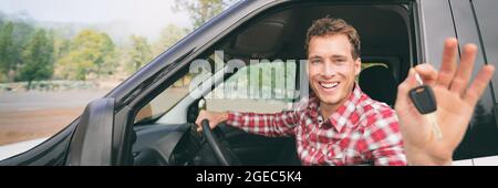 New car young man driver happy holding keys driving rental on road trip vacation travel holiday banner panoramic background. Drive lifestyle Stock Photo