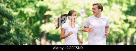 Run exercise fitness friends walking running talking together on fun race in city park panoramic banner background. Healthy active lifestyle young Stock Photo