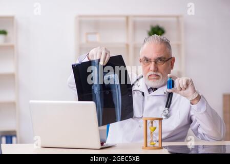 Old doctor in time management concept Stock Photo