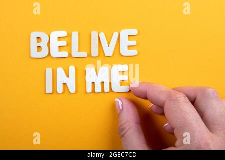 Belive In Me. White wooden letters with text on a yellow background. Stock Photo