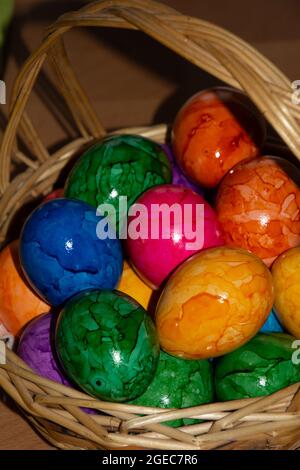 simple easter concept with bright colored easter eggs in wicker basket Stock Photo