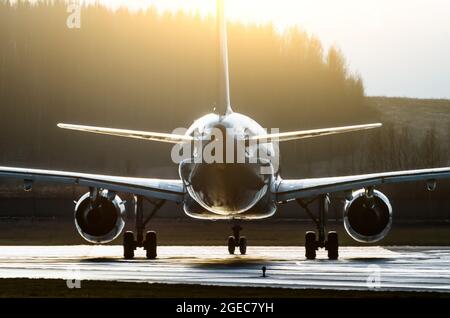 Silhouette of an aircraft illuminated by the sun contours contrast on a runway Stock Photo