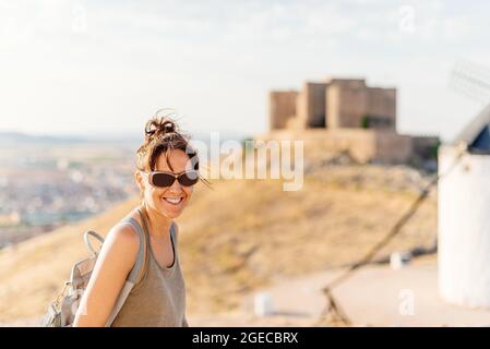 Young woman smiling at the camera with a castle in the background Stock Photo