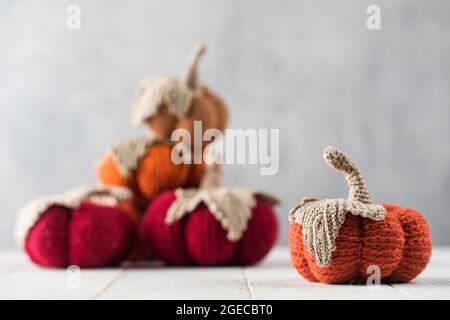 Handmade knitted pumpkins with leaves on white table Stock Photo