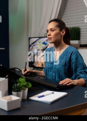 Creative editing artist using retoucher software on photo sitting at desk while working with photography editing equipment. Young woman retouching project on desktop monitor computer Stock Photo
