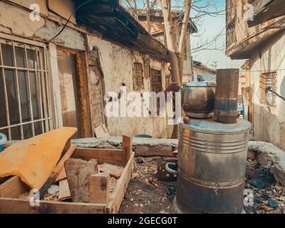 Blackened metal  teapot on old samovar stove in the back streets of Ulus, Ankara,  Tumbledown slums in an alley of Ulus district. Stock Photo