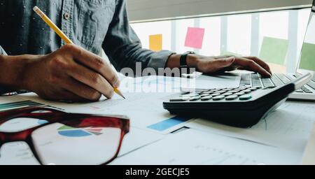 close up businessman pointing at graph and chart to analysis use for plans to improve quality, business finances and accounting concept Stock Photo