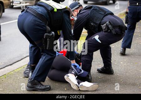 Melbourne, Australia, 7 July, 2020. A woman standing on the street in support of the residents inside of 120 Racecourse road is violently slammed to the ground and arrested as police swarm on a small number of people amid the third full day of the total lockdown of 9 housing commission high rise towers in North Melbourne and Flemington during COVID 19.After recording 191 COVID-19 cases overnight forcing Premier Daniel Andrews to announce today that all of metropolitan Melbourne along with one regional centre, Mitchell Shire will once more go back to stage three lockdowns from midnight Wednesda Stock Photo
