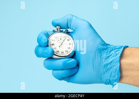 Doctor in glove holds stopwatch in his hand. Fast medical assistance and consultation concept. Stock Photo