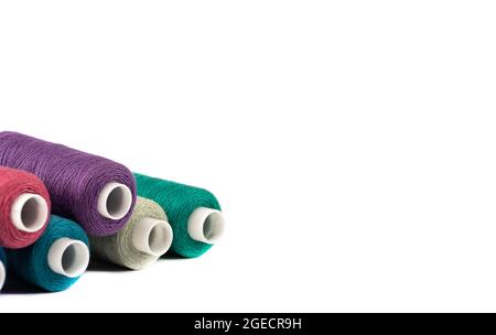 Spools of thread isolated on white with space for text. Horizontal positioning of the frame. The spools are on the left side. Stock Photo
