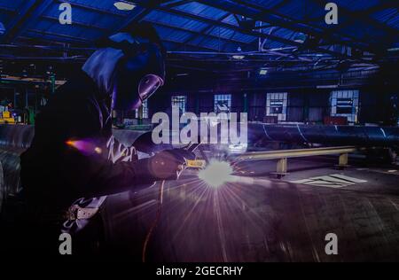 Pipe manufacturing plant. Large diameter Metal pipes factory welding the rolled metal Stock Photo