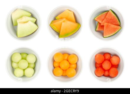 Melon slices and balls in white bowls. Galia, honey Cantaloupe melon and watermelon, freshly cut out spheres and triangular shaped pieces. Stock Photo