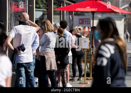 Melbourne, Australia, 29 August, 2020. People line up for coffee ignoring social distancing rules. Spring has arrived as Melbournians declare 'crisis' over as they venture out of their homes in huge numbers to enjoy the sun despite Premier Daniel Andrews pleading them to stay indoors during COVID-19 in Melbourne, Australia. Premier Daniel Andrews is said to have struck a deal with the cross benchers allowing his controversial plans for extending the State of Emergency for a further 12 months. This comes as new COVID-19 infections dropped below 100 for the first time since the second wave began Stock Photo