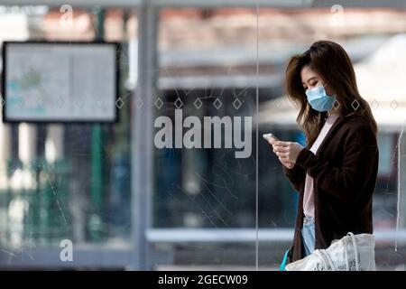 Melbourne, Australia, 9 September, 2020. A woman wearing a mask is seen looking at her phone as she waits for a tram during COVID-19 in Melbourne, Australia. Victoria records a further 76 cases of Coronavirus over the past 24 hours, an increase from yesterday along with 11 deaths. This comes amid news that AstraZeneca pauses vaccine study. Credit: Dave Hewison/Speed Media/Alamy Live News Stock Photo