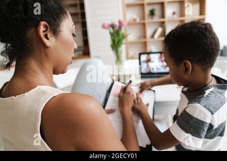 Black mother and son using laptop while working at home Stock Photo