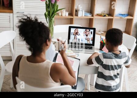 Black mother and son using laptop while working at home Stock Photo