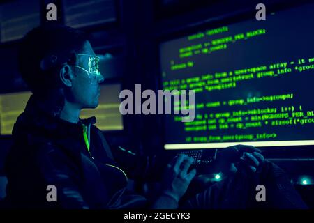 Cyber hacker breaks into databases to obtain information using a computer. Cybercrime and data security concept. Stock Photo
