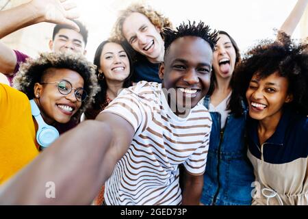 Group of multiracial happy best friends taking selfie photo with smartphone Stock Photo