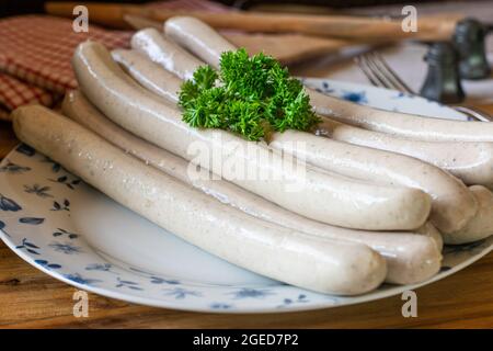 Traditional german brewed  'thüringer bratwurst' Thuringian Bratwurst. Raw on a rustic plate on wooden table. Ready to grill Stock Photo