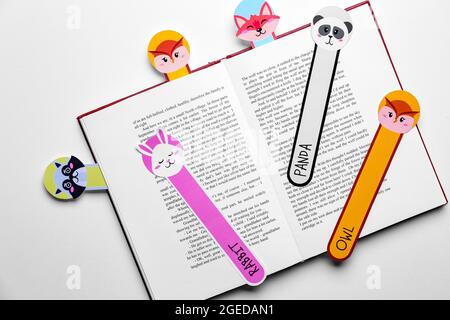 Cute bookmarks with book on light background Stock Photo