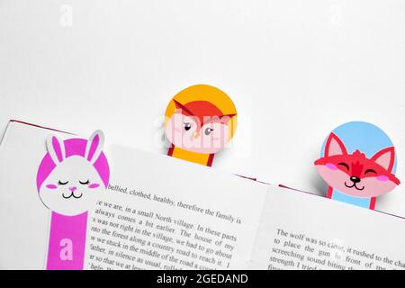 Cute bookmarks with book on light background Stock Photo