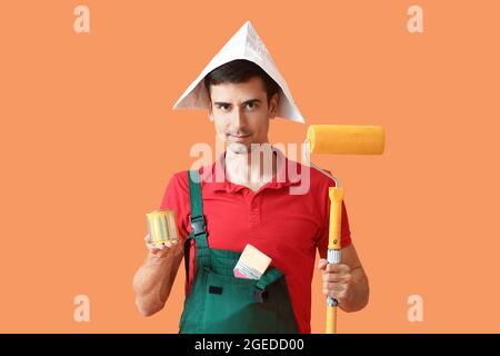 Male painter with roller brush on color background Stock Photo