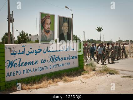 Gen. Stanley McChrystal, commander of NATO's International Security Assistance Force, the Mayor of Hairaton, provincial officials and members of the Afghan Border Police pass the 'Welcome to Afghanistan' sign on their way to the Freedom Bridge crossing the Amu Darya River. On Feb. 15, 1989, the last Soviet troops to withdraw from Afghanistan crossed the bridge into the, then, Uzbek Soviet Socialist Replublic. Stock Photo