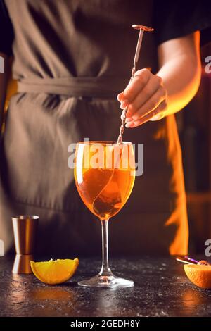 Woman preparing tasty aperol spritz cocktail at table, closeup Stock Photo