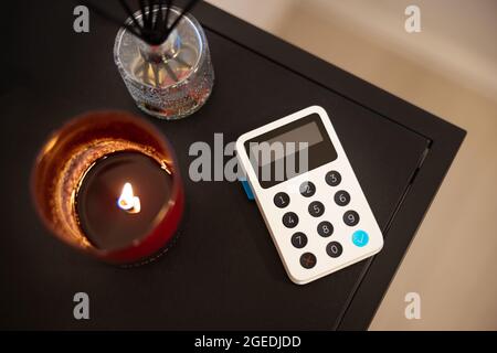 White Card Reader By Tealight On Table Stock Photo