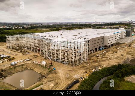 Aerial view of a large distribution centre warehouse on the outskirts of a large city being built and under construction Stock Photo