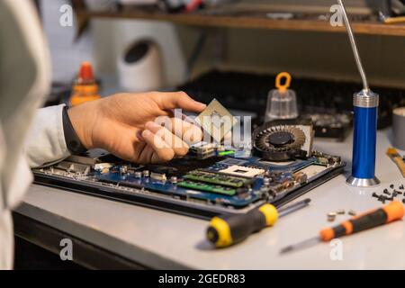 Computer repair technician repairing a laptop Stock Photo