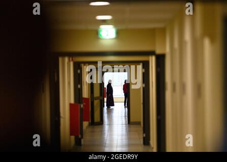 Doberlug Kirchhain, Germany. 19th Aug, 2021. Two women stand at the end of the corridor in a residential building of the initial reception facility for refugees and asylum seekers run by the DRK Refugee Aid. According to the Central Foreigners Authority of Brandenburg, the arrival of the first local forces from Afghanistan is expected here during the night. In the multi-storey house, rooms are prepared for the arrival on an upper floor. Credit: Soeren Stache/dpa-Zentralbild/dpa/Alamy Live News