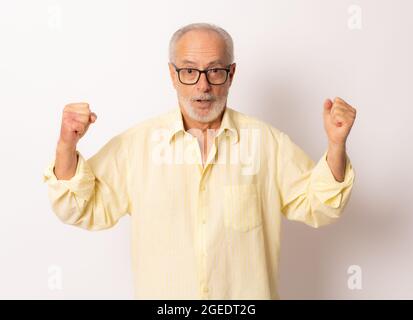 Senior man making the winner gesture over white background. Stock Photo