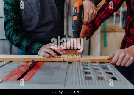 Senior carpenter teaching his younger student how to work Stock Photo