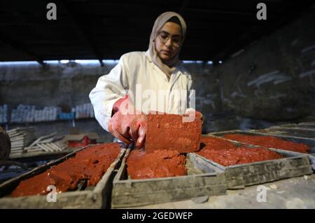 Tulkarem. 12th Aug, 2021. Rawan Rajab works on turning the waste of glass into eco-friendly building stones at her workshop in the West Bank City of Tulkarem, Aug. 12, 2021. TO GO WITH 'Feature: Young Palestinian woman turns glass waste into eco-friendly building stones' Credit: Ayman Nobani/Xinhua/Alamy Live News Stock Photo
