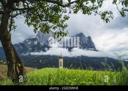St Valentine's Church, Seis am Schlern, Italy. Schlern mountain with rainy clouds in background Stock Photo