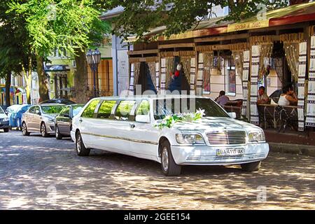 ODESA, UKRAINE - JULY 21, 2012: Limousine by Mercedes brand decorated for wedding near restaurants on the street of the city Stock Photo