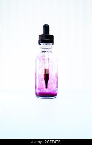 glass flask with purple paint on white background Stock Photo