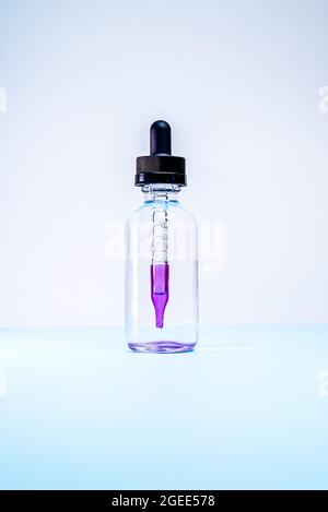 glass flask with purple paint on white background Stock Photo