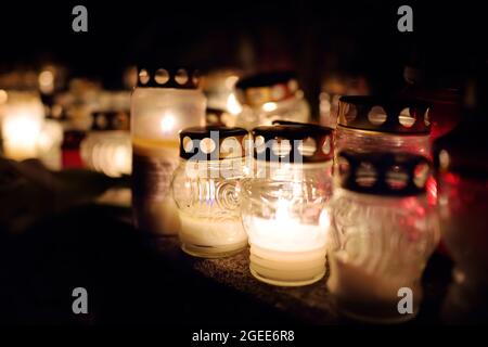 Candles lit up on All Souls Day in Lithuania. Candle flames illuminating a Lithuanian cemetery during All Saint's Day. Stock Photo